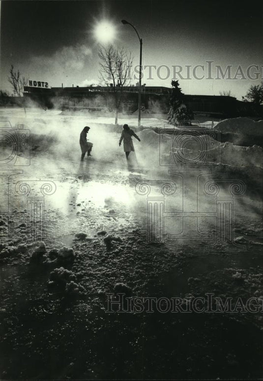 1982 Press Photo Women wade thru slush after water main break, Milwaukee - Historic Images