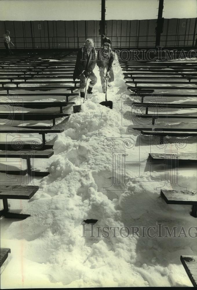 1982 Press Photo Ray Priest and Tim Brown shovel snow, County Stadium bleachers - Historic Images