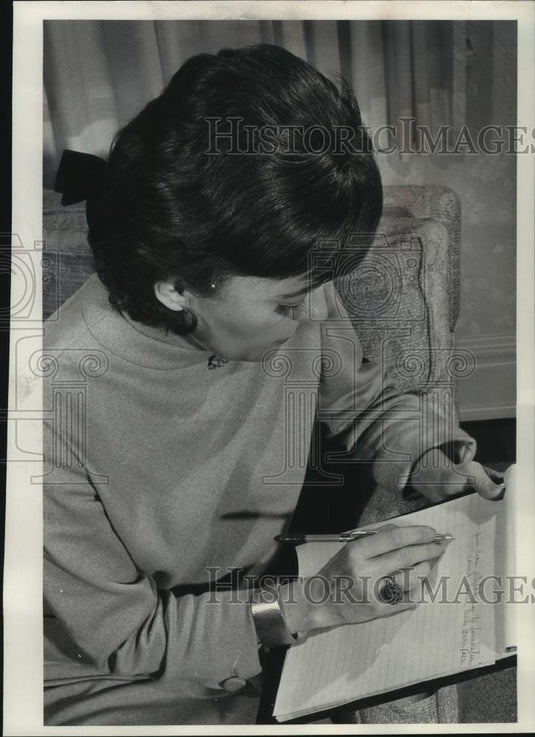 1985 Press Photo Mrs. Warren Knowles wears a wiglet in her hair as she writes. - Historic Images