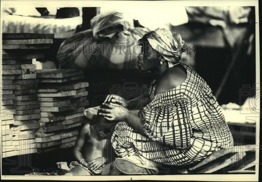 1988 Press Photo A mother tended her child at the marketplace, Africa - Historic Images
