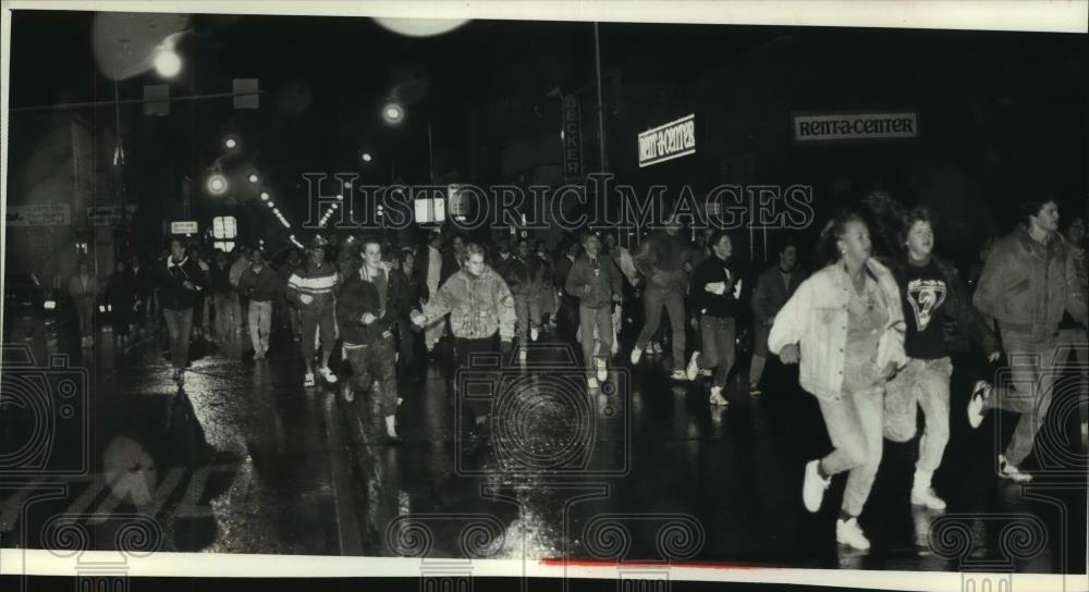 1989 Press Photo crowd runs on Oshkosh Main Street after police raided a party - Historic Images