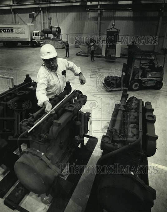 1990 Press Photo Ed Behling measures engine at Transpak Corp for packaging - Historic Images