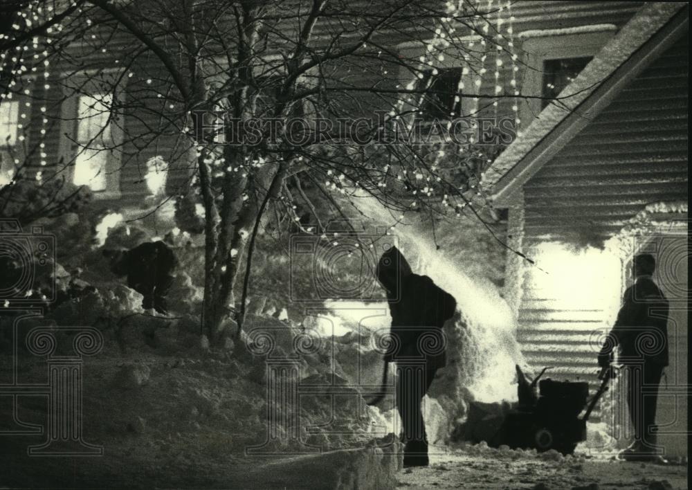 1990 Press Photo The Lindl family clear snow under Christmas lights in Waukesha. - Historic Images