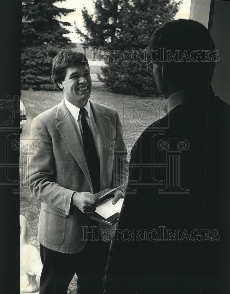 1990 Press Photo Reverend John Schindler invites Franklin resident to service. - Historic Images