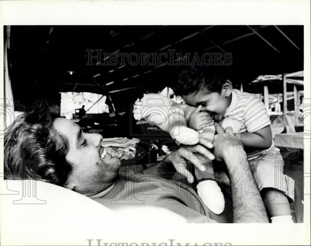 Press Photo A Cuban refugee plays with his son - Historic Images