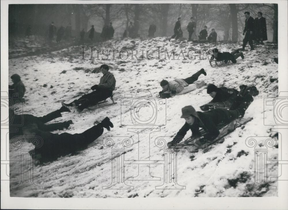 1956 Press Photo People Ride Down Snow Covered Slopes Hampstead Heath London - Historic Images