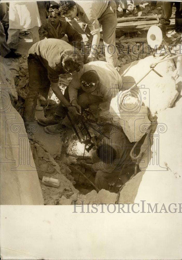 1960 Press Photo Lowering a man down a hole - Historic Images