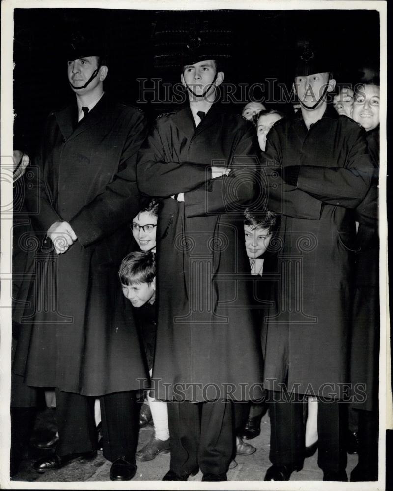 Press Photo Three youngsters poke their head between legs of the police guard - Historic Images