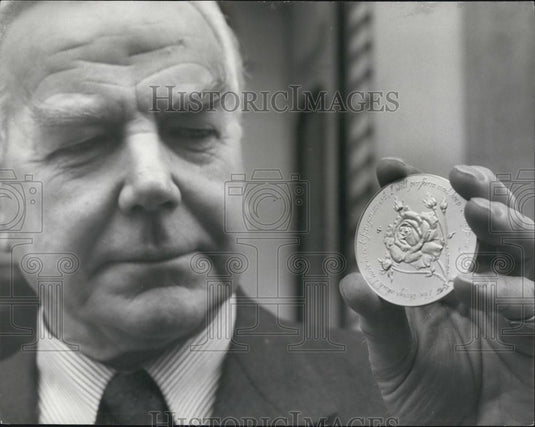 1977 Press Photo Phillip Spink Chairman of Spink & Son Examines Jubilee Medal - Historic Images