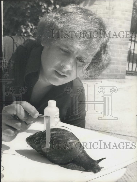 Press Photo Chris Hudson measures a huge snail found in W. Africa - Historic Images