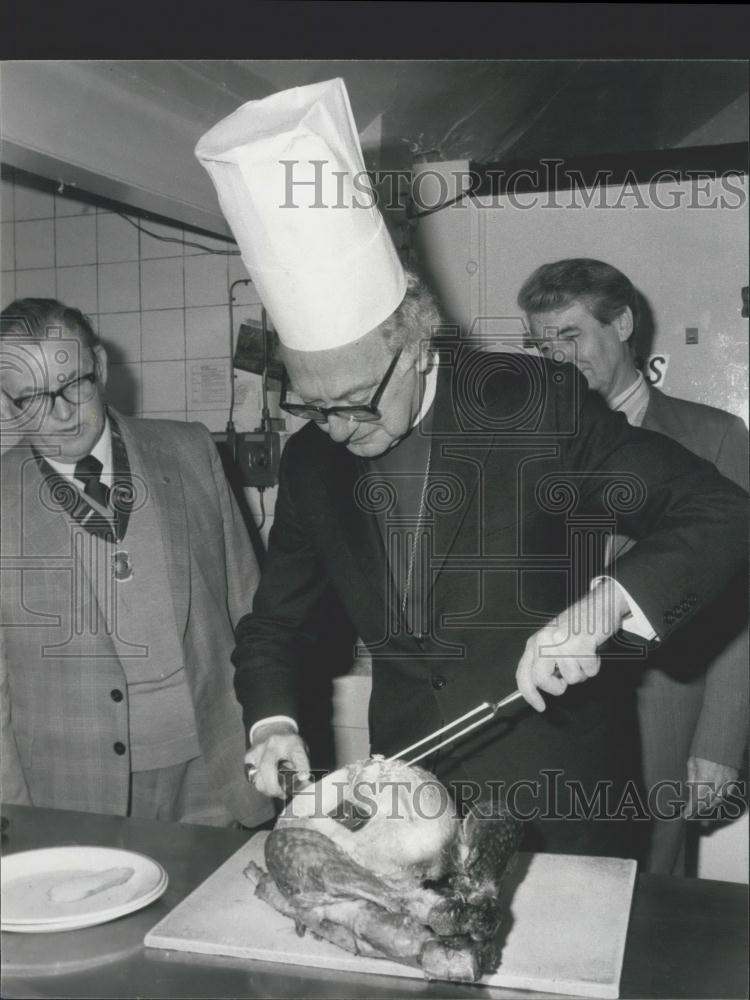 1980 Press Photo ,The Archbishop of Canterbury carving a turkey - Historic Images