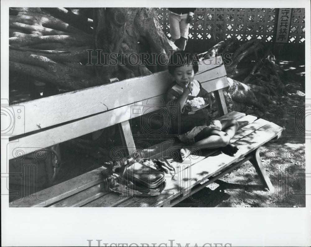 Press Photo Young Girl Eating Lunch Recreation Park Taiwan Kaohsuing - Historic Images