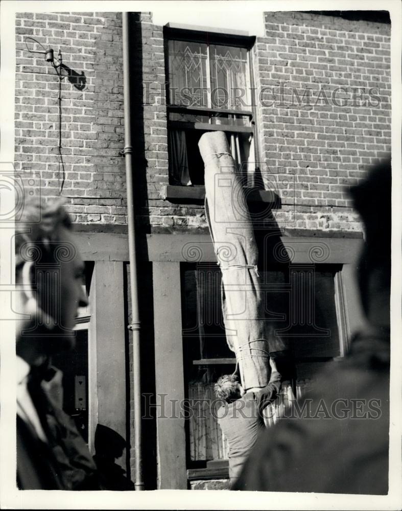 1957 Press Photo Carpets being removed from home as sinkhole may swallow home - Historic Images