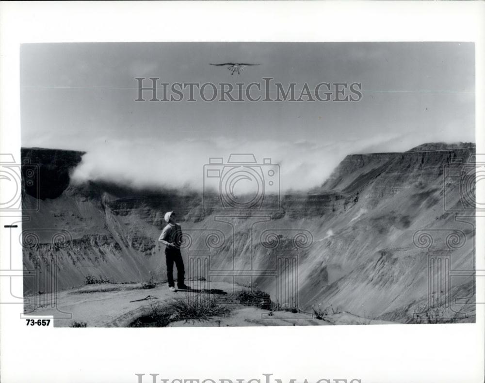 Press Photo research team watches a hawking over a volcanic caldera. - Historic Images