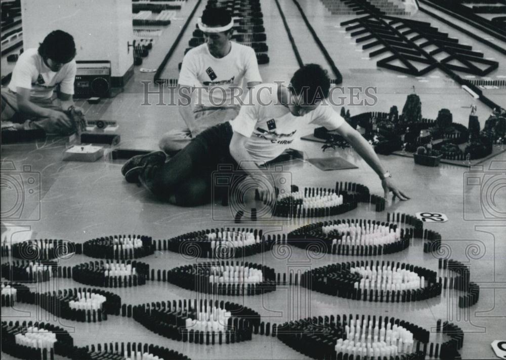 Press Photo Michael Cairney seen cautiously setting domino pieces - Historic Images