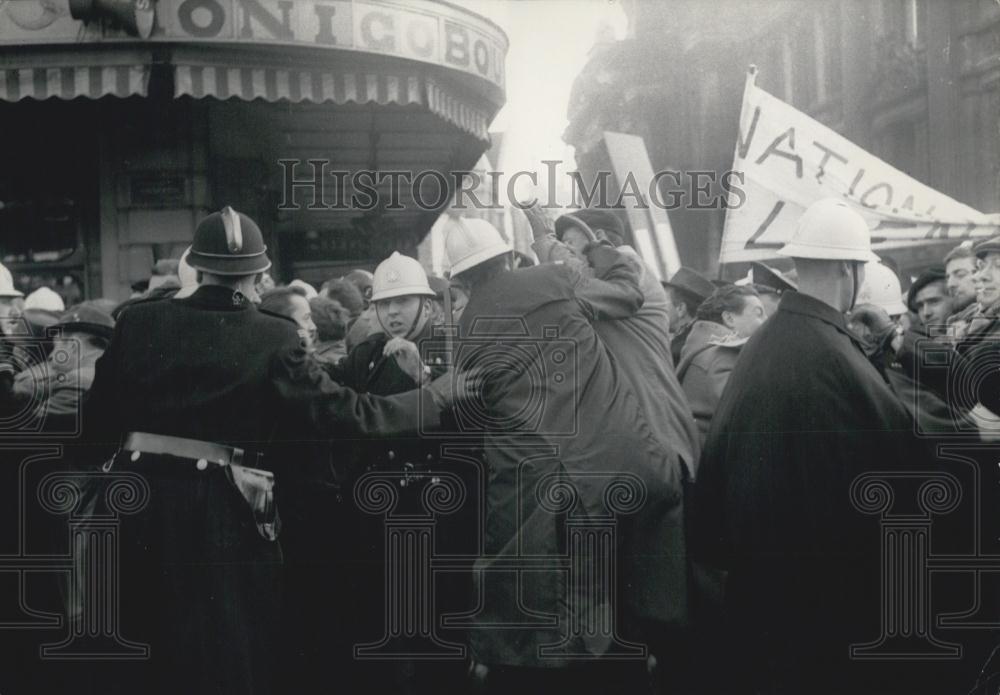 1960 Press Photo Policeman pushing away the rioters in the streets of Brussels - Historic Images