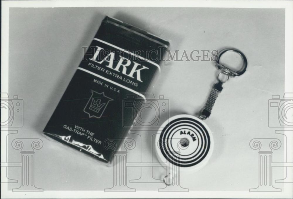 Press Photo Lark Cigarettes Comes With Tiny Alarm Key Chain - Historic Images