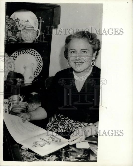 1956 Press Photo Miss Sheila Lind with Picture in Catalog of Rare Clock - Historic Images