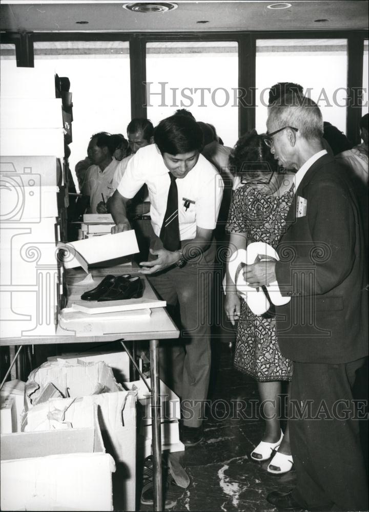 Press Photo Asian Man And Woman Being Checked For Illegal Items - Historic Images