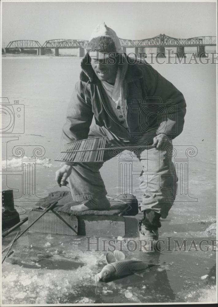 Press Photo Fisherman and the carp he caught - Historic Images