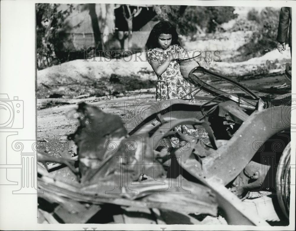 1961 Press Photo Refugee from Bizerta gazes at the burnt out wreck of a car - Historic Images