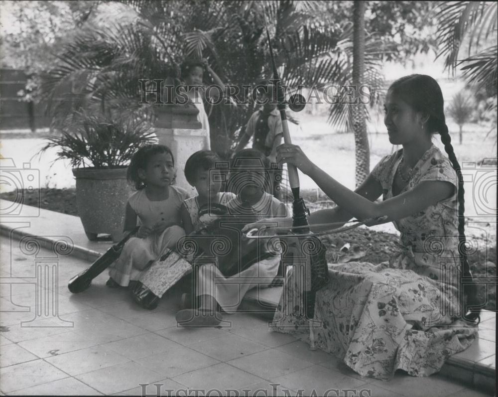 Press Photo Japanese children returning from school sit and watch a girl - Historic Images