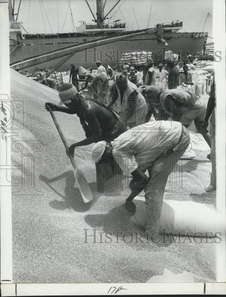 Press Photo Grain Stockpile Dakar Harbour Workers Filling Bags Drought - Historic Images