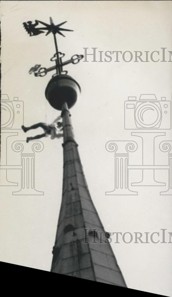 Press Photo Artist hangs on a steeple - Historic Images