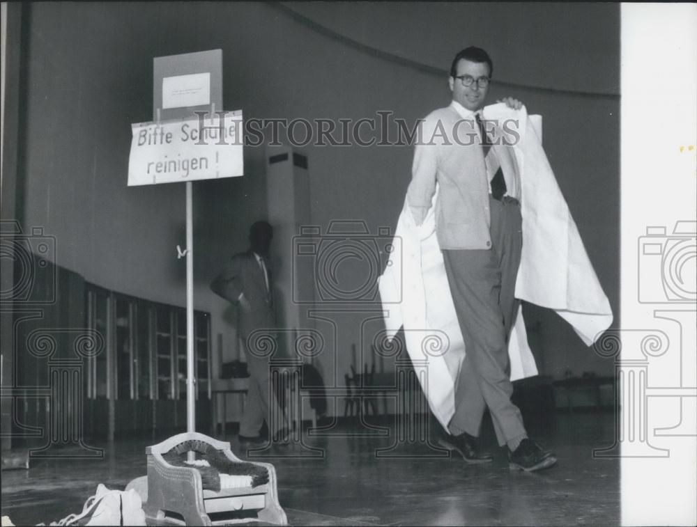 Press Photo German Scientist Putting On His Lab Coat - Historic Images