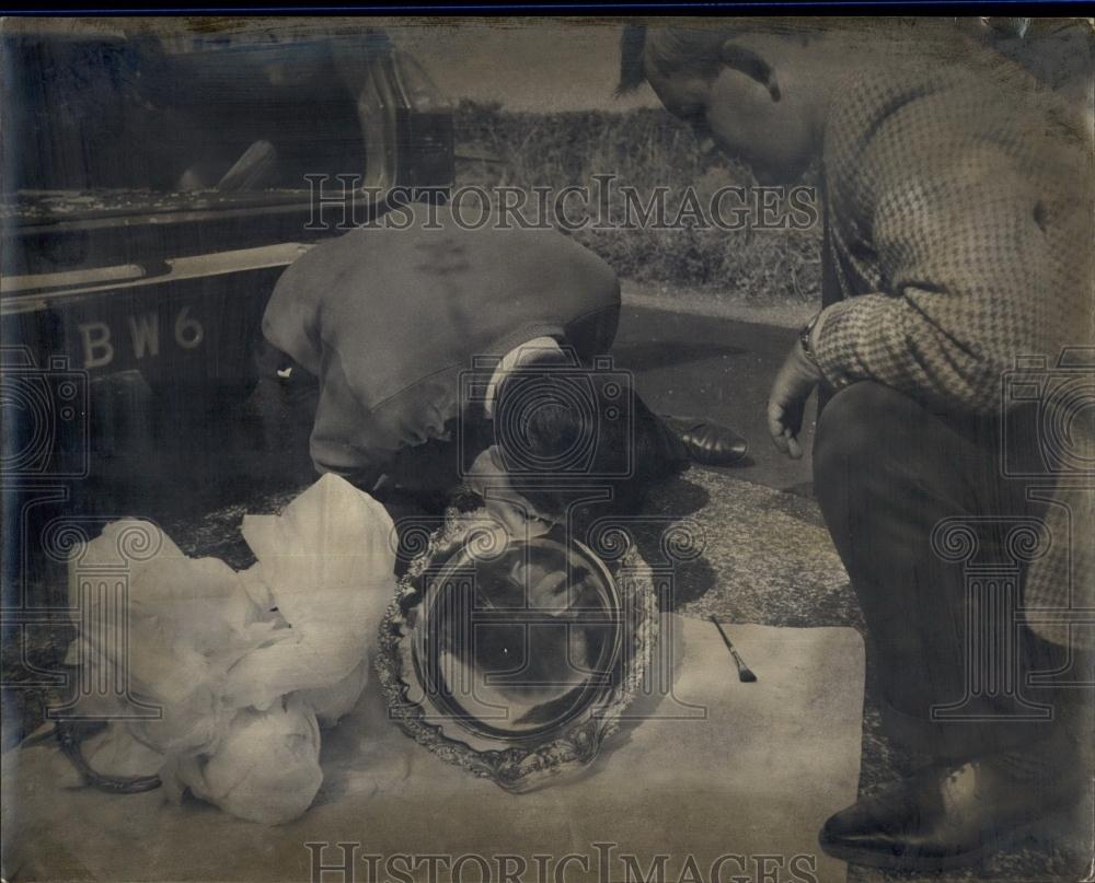 1967 Press Photo Detective examining a silver salver which was left behind - Historic Images