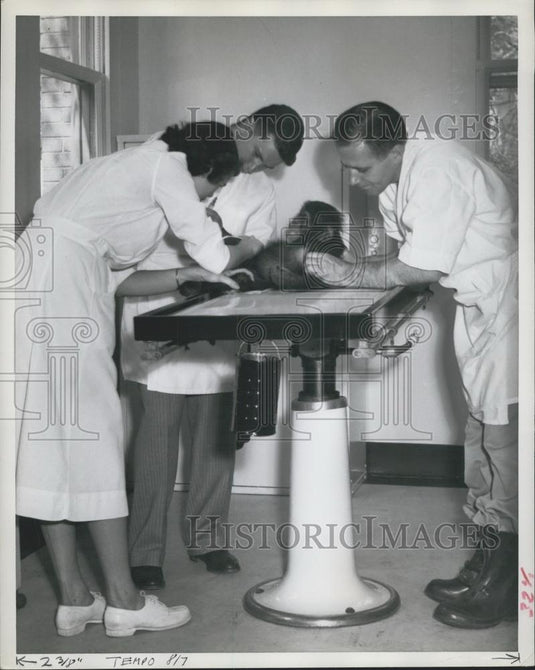 Press Photo poor little chimp setting the once over by big animal doctors. - Historic Images