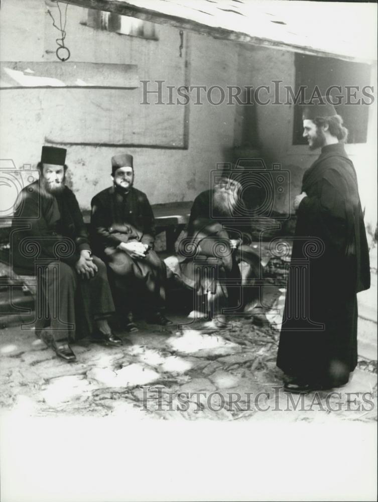 Press Photo Athenos Monks sitting outdoors on sunny day - Historic Images