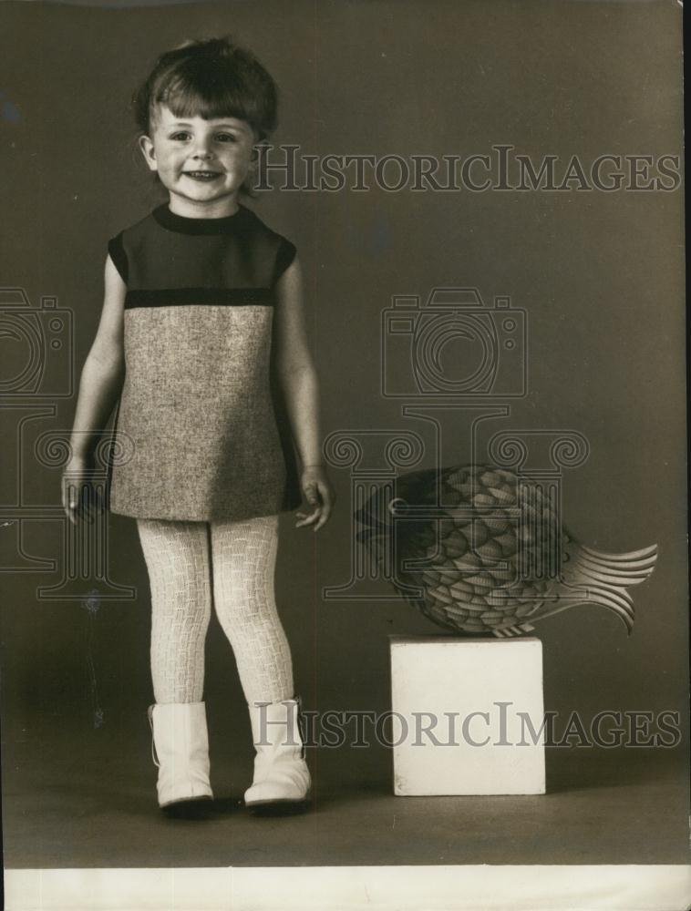 Press Photo A Child Poses Next To A Fake Pufferfish On A Box - Historic Images