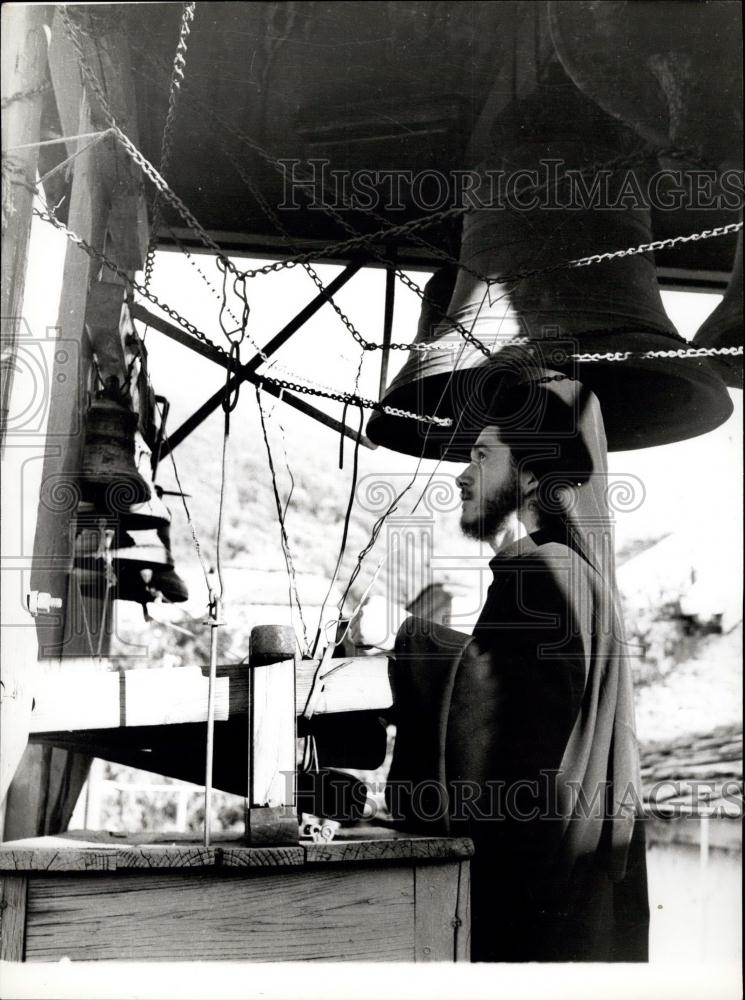 Press Photo An under-aged trainee-monk ringing the bell calling for prayers - Historic Images