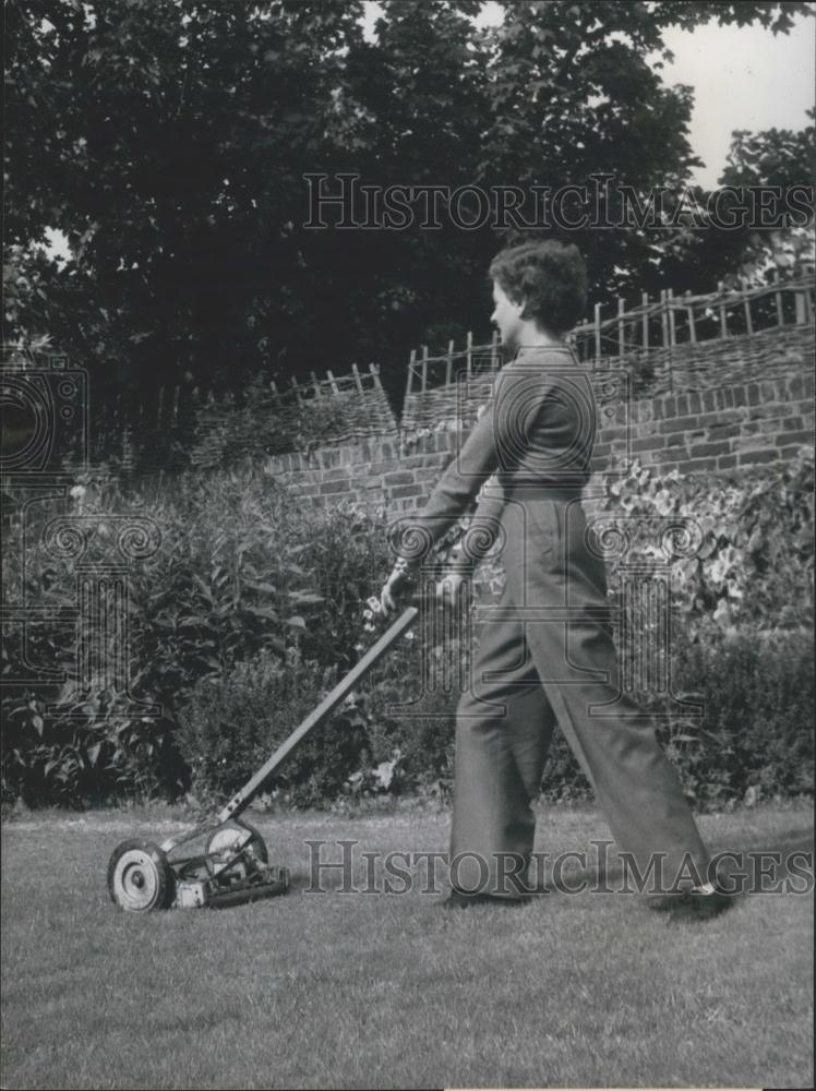 Press Photo Trimming the grass keeps your figure in trim - Historic Images