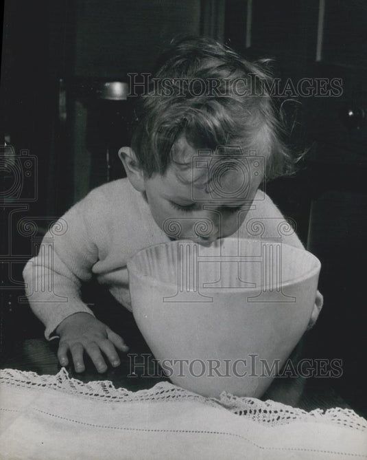 Press Photo Child Looks for Treats in a Mixing Bowl - Historic Images