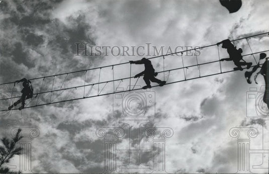 Press Photo troops traverse a ravine on the three rope bridge - Historic Images