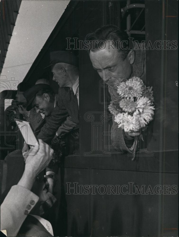 Press Photo Man Reading Card During International Night Holding Flowers - Historic Images