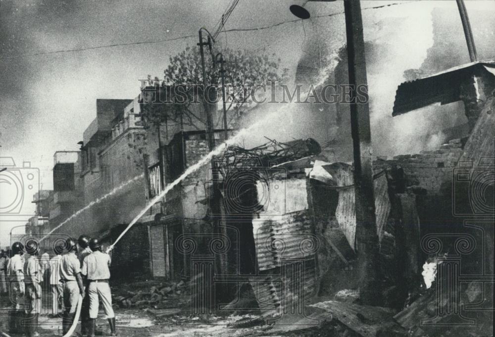 1974 Press Photo Fire brigade men extinguishing the burning shops in Delhi - Historic Images