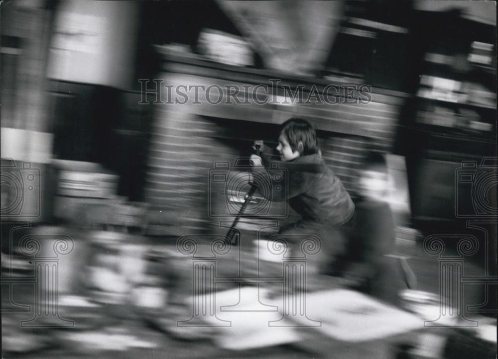 Press Photo Speeding through the class-room on a scooter - Historic Images
