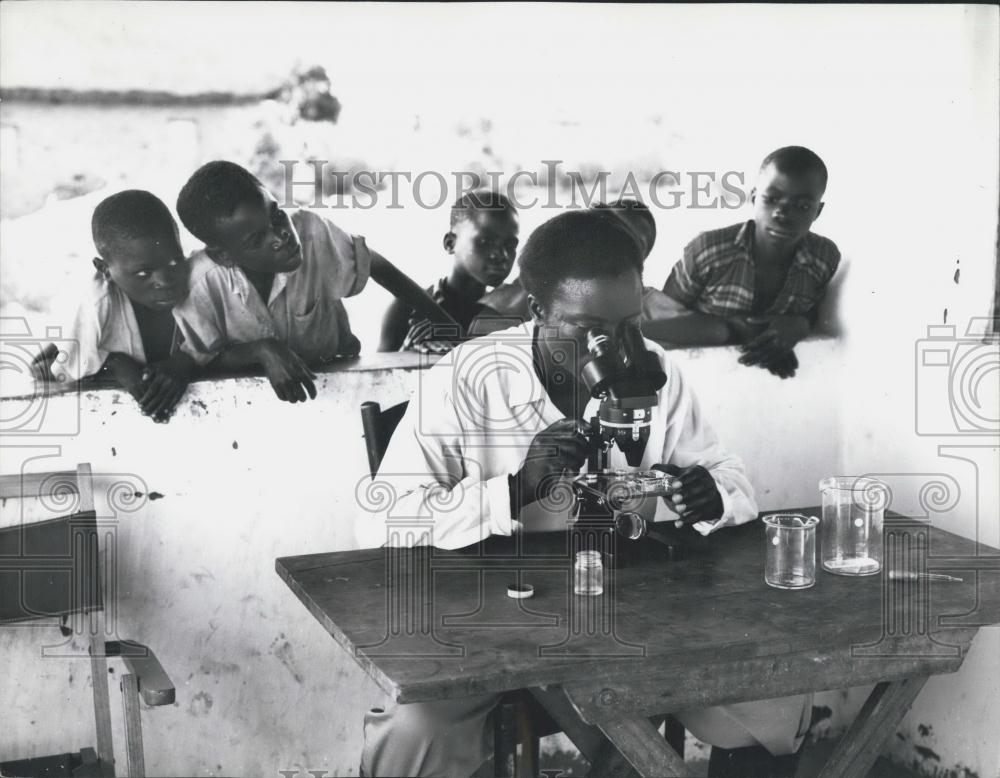 Press Photo Man Performs Microscopic Examination Of Wine Zambia Children Watch - Historic Images