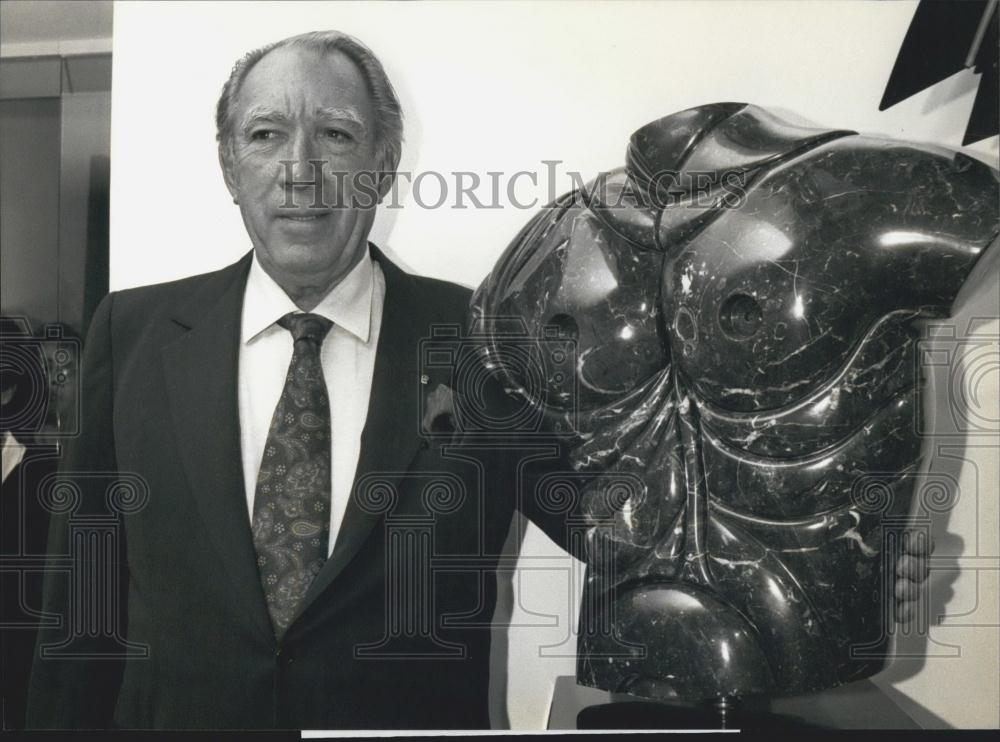 1990 Press Photo Actor Anthony Quinn poses beside his sculpture Apollo - Historic Images