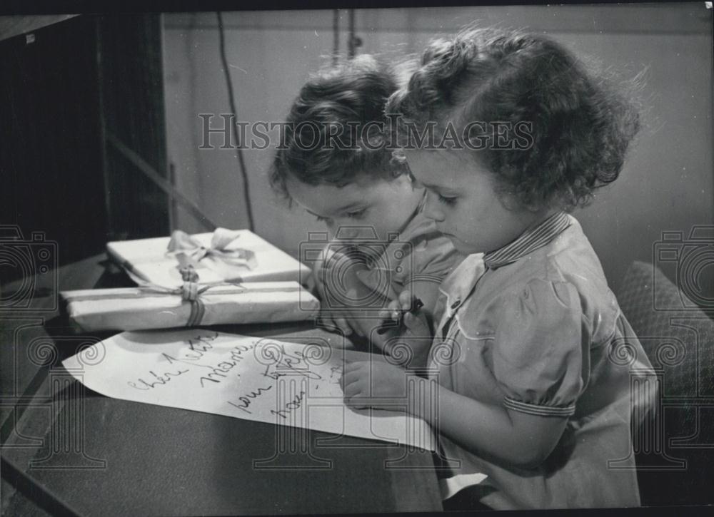 Press Photo Jean-Claude and his little brother pay attention to write the compli - Historic Images