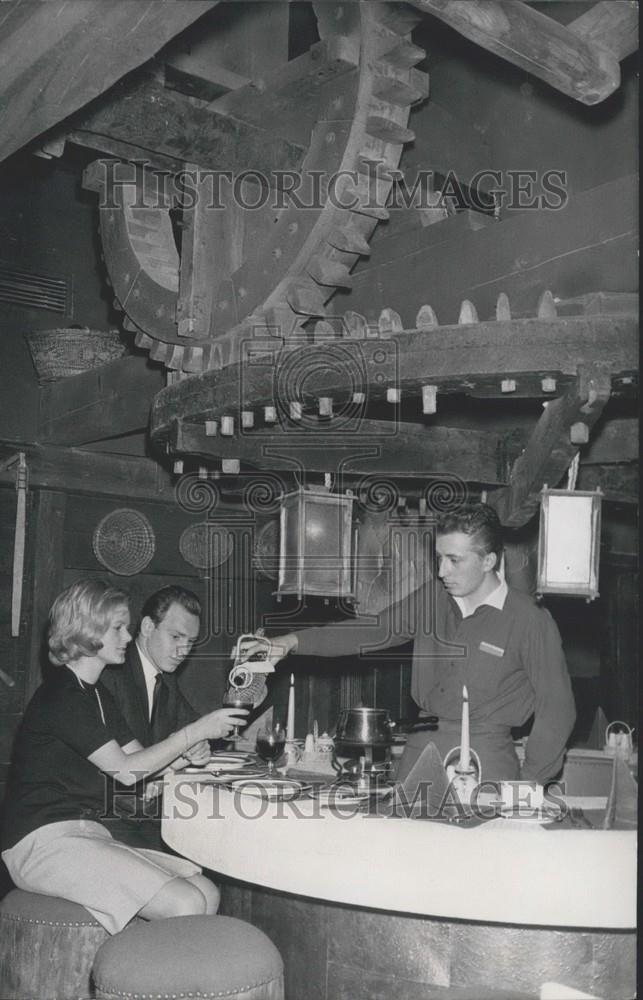 Press Photo Server pours drink for couple - Germany. - Historic Images