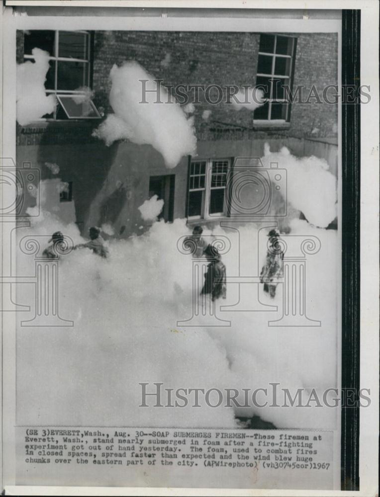 1967 Press Photo Firemen submerged in foam after fire-fighting experiment - Historic Images