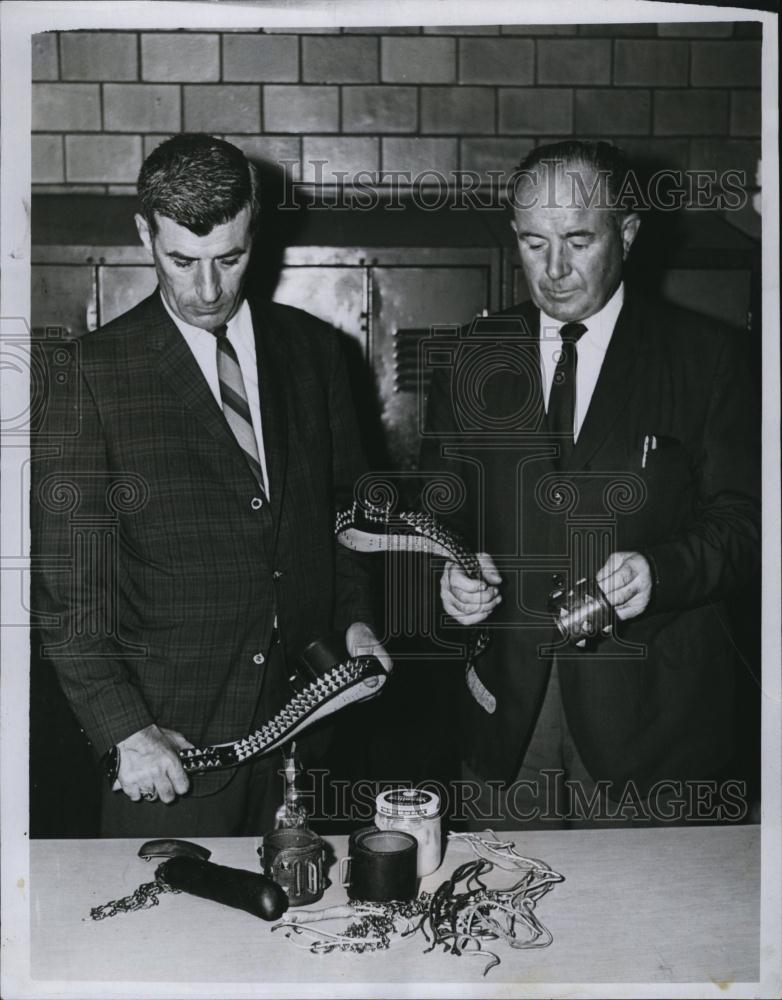 1967 Press Photo Detectives Mahoney & Patrick Look at Torture Tools Seized - Historic Images