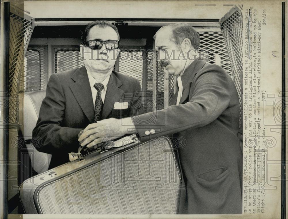 1975 Press Photo A Federal Marshall hands a suitcase to Antulio Ramirez Ortiz - Historic Images