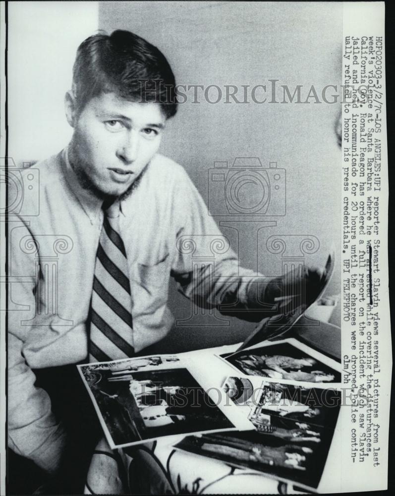 1970 Press Photo Reporter Stewart Slavin Viewing Pics Of Violence In City - Historic Images