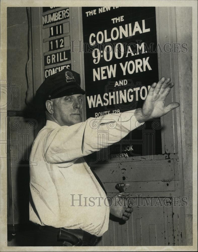 1960 Press Photo Officer Herb Fay, pulling down the Colonial Schedule curtain - Historic Images