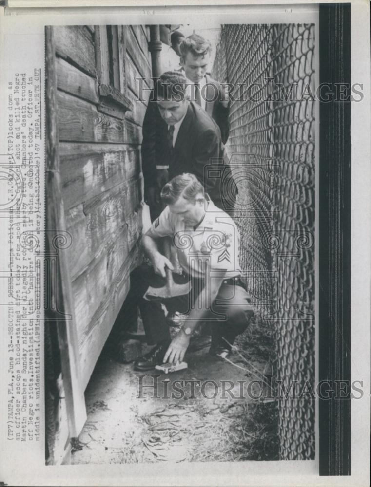 1967 Press Photo JR Calvert officer scoops up blood stained - RSL65883 - Historic Images